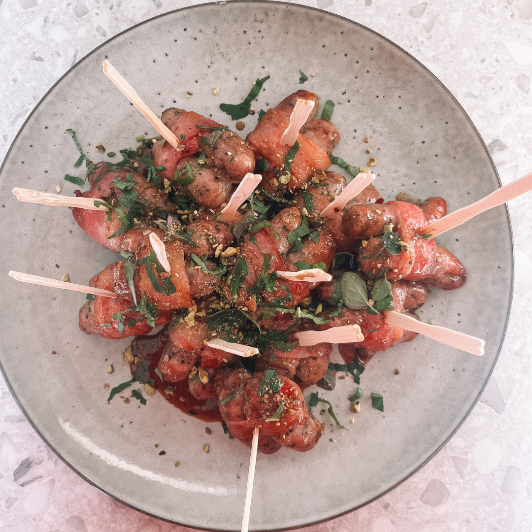 Sticky pomegranate and pistachio pigs in blankets